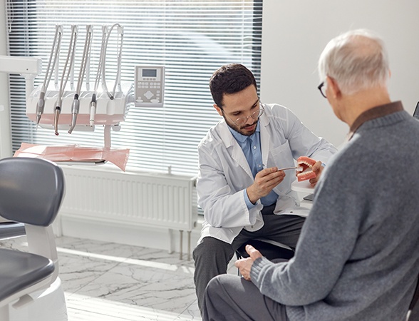 Dentist talking to older male patient