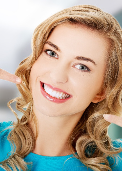 A woman pointing to her teeth