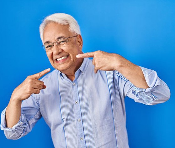 Happy senior man pointing at his smile